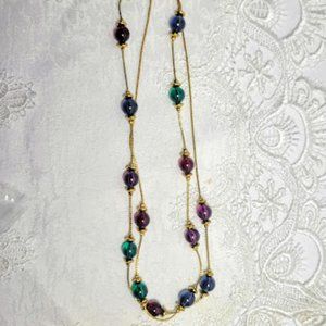 GOLD COLOR NECKLACE WITH ROUND RED, GREEN, BLUE AND PURPLE BEEDS APPROX 35" LONG